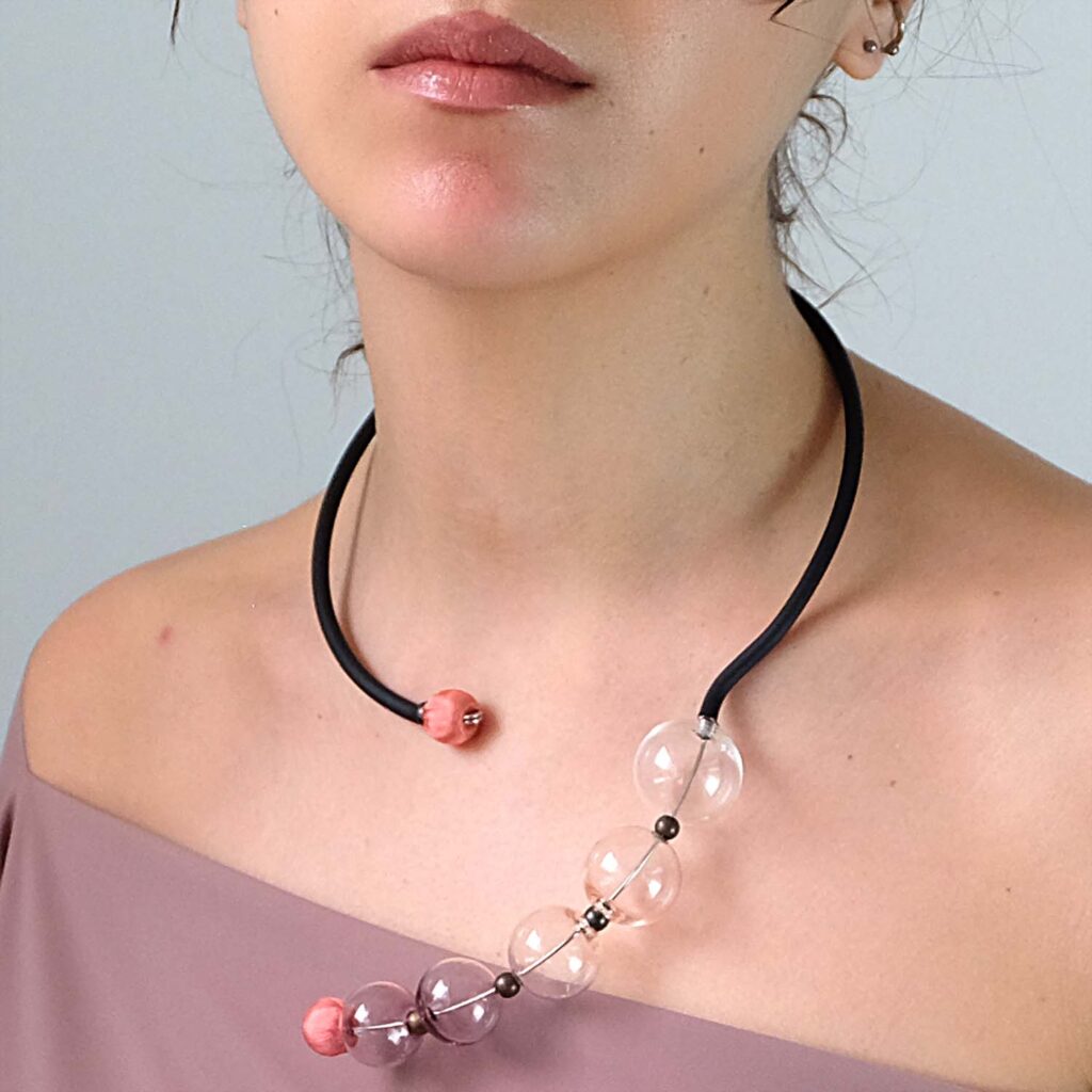 Saval è una collana moderna e strutturata, caratterizzata da perle in vetro soffiato di Murano e una forma geometrica